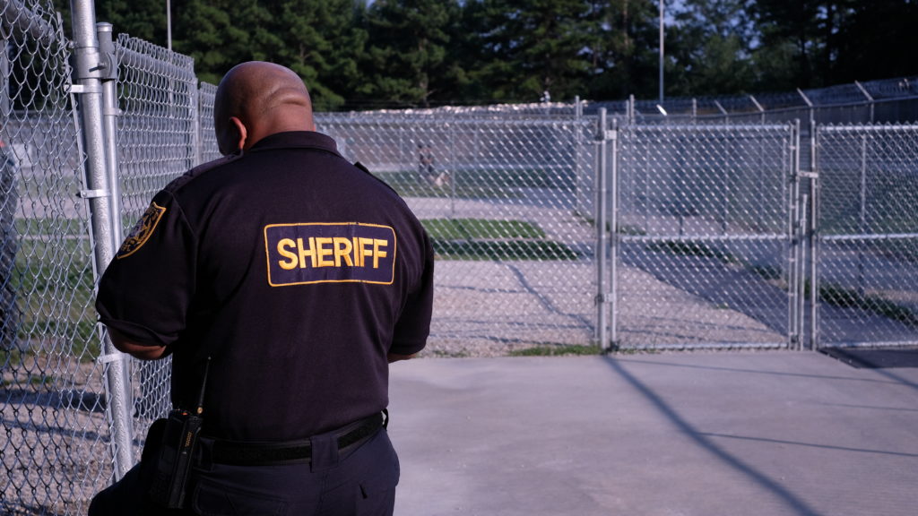 Sheriff near fence